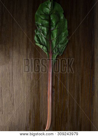 Fresh Raw Leaves Of Chard, Leaf Beets, Mangold, Swiss Chard On A Wooden Table, Close Up