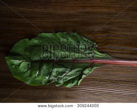 Fresh Raw Leaves Of Chard, Leaf Beets, Mangold, Swiss Chard On A Wooden Table, Close Up