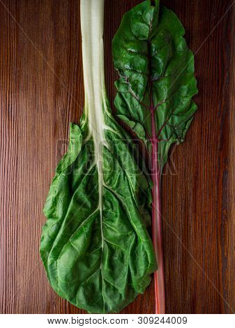 Fresh Raw Leaves Of Chard, Leaf Beets, Mangold, Swiss Chard On A Wooden Table, Close Up