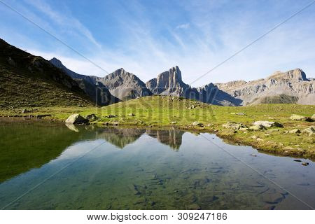 Peaks reflected in Ansabere Lake. Lescun Cirque. Aspe Valley, Pyrenees, France.