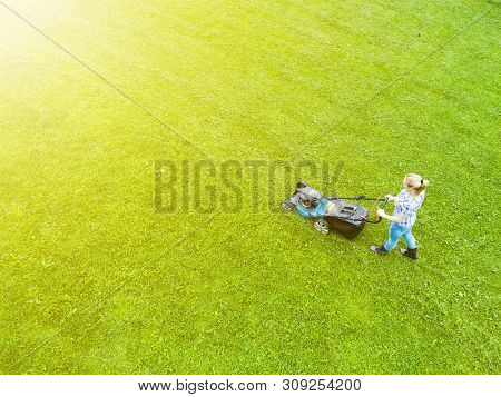 Beautiful Girl Cuts The Lawn. Mowing Lawns. Aerial View Beautiful Woman Lawn Mower On Green Grass. M