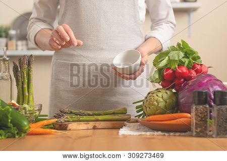 The Chef Cleans Asparagus, With Vegetables On A Light Background. The Concept Is Loss Of Healthy And