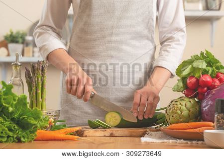 The Chef Cuts Cucumber On A Light Background. A Concept Of Losing Healthy And Wholesome Food, Detox,