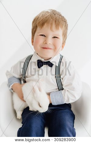 Caucasian Little Boy Posing With Rabbit Portrait. Happy Redhead Infant Kid Holding Flaffy Easter Bun