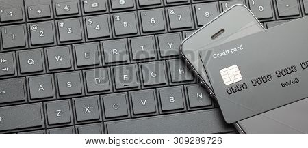 Black Style. Credit Card And Mobile Phone Smartphone On The Keyboard With Laptop. Online Payment For