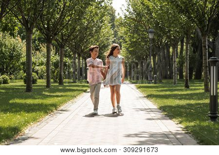 You Are My Best Frind. Little Boy And Girl Holding Hands And Smiling While Walking Together In Park