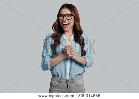 So Happy! Attractive Young Woman Cheering While Standing Against Grey Background