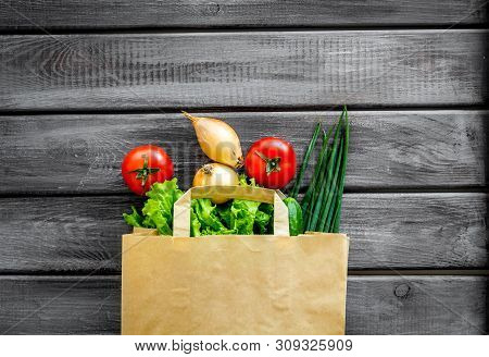 Healthy Food With Fresh Vegetables In Paper Bag On Wooden Background Top View