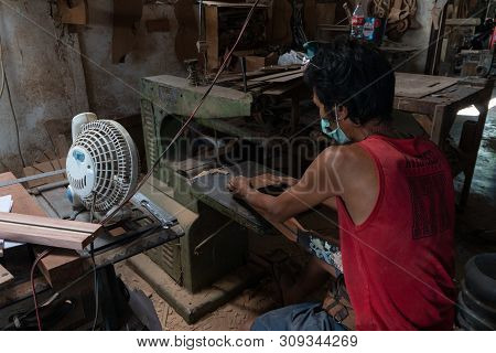 Gianyar,bali/indonesia-may 30 2019: A Guitar Craftsman Is Cutting To Make Sure His Guitar Precision