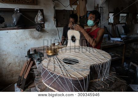 Gianyar,bali/indonesia-may 30 2019: A Guitar Craftsman Is Measuring And Make Sure It Is Precision In