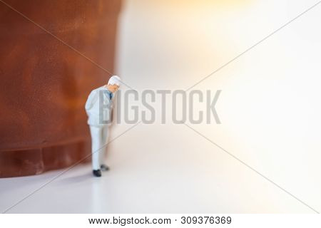 Business Concept. Businessman Minaiture Figure Standing And Thinking  With Plastic Cup Of Iced Black