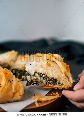 Slice Of Greek Pie Spanakopita In Hand. Ideas And Recipes For Vegetarian Or Vegan Spanakopita Spinac