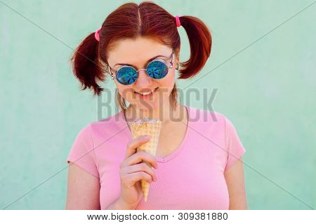 Smiling Audacious Young Woman With Pigtails Hairstyle Holds Ice-cream In Waffle Cone, It Reflects In