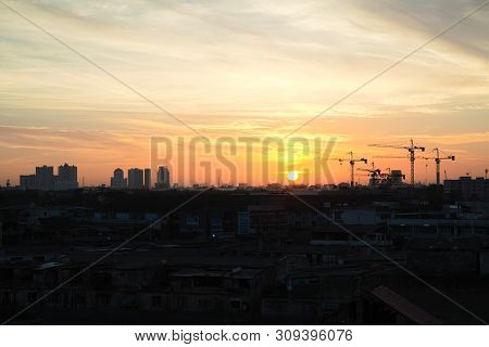 Silhouette Of Cranes Ready To Work After Sun Appear