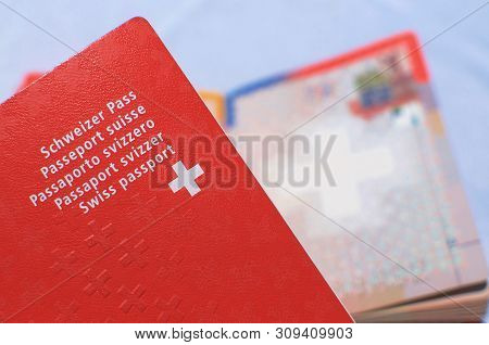 Close Up View Of One Swiss Passport With A Blurred Open Swiss Passport On The Background