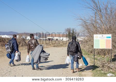 Gevgelija, Macedonia - December 13, 2015  Refugees Standing At The Entrance Of Vinojug Camps Near Th