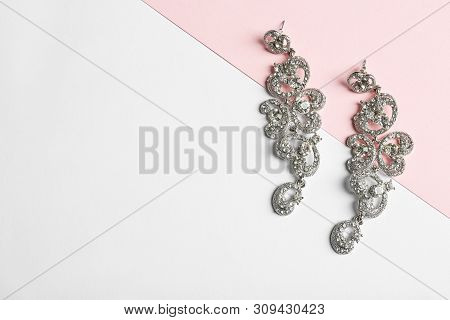 Elegant Earrings On Color Background, Top View With Space For Text. Luxury Jewelry
