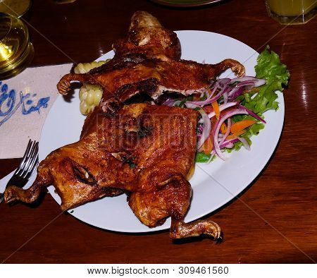 Close-up View To Grilled Cuy Aka Guinea Pig, Traditional Peruvian Dish With Salad Arequipa, Peru