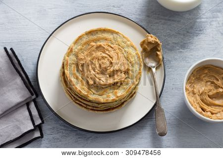 Vegan Pancakes With Flax Seeds, Peanut Butter And Vegan Milk On A White Plate On A Gray Background. 