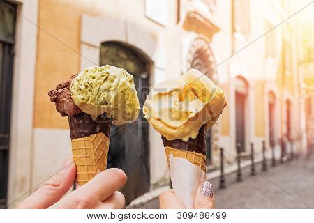 Two Hands Close-up Holding Cones With Italian Ice-cream Gelato On The Background Of Rome Streeet