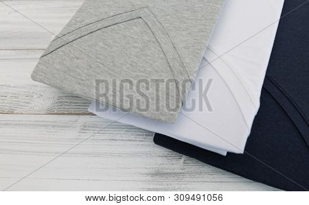 New Black, White And Grey V Neck Shirt On White Wooden Background