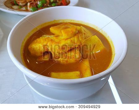 Thai Food Style,top View Sour Soup With Snapper And Young Coconut Shoots In White Bowl On Table At R