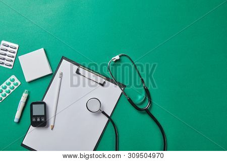 Top View Of Blood Lancet, Sticky Notes, Blister Packs And Stethoscope Near Glucometer And Pencil On 