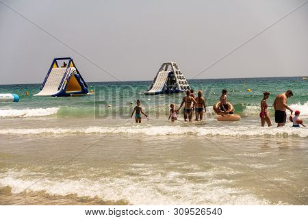 Mil Palmeras, Costa Blanca, Spain - July 02 2019: People On Beach Enjoying The Sun And Playing On In