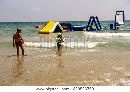 Mil Palmeras, Costa Blanca, Spain - July 02 2019: People On Beach Enjoying The Sun And Playing On In