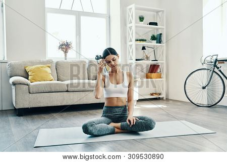 Just A Minute To Rest. Beautiful Young Woman In Sports Clothing Practicing Yoga And Drinking Yoga Wh