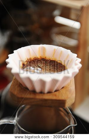 Blooming Coffee In Pink Ceramic Origami Dripper. On Wooden Coffee Stand. Close Up. Alternative Manua