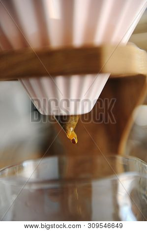 Close Up Coffee Dripping. Alternative Brewing In Pink Ceramic Origami Dripper On Wooden Stand.