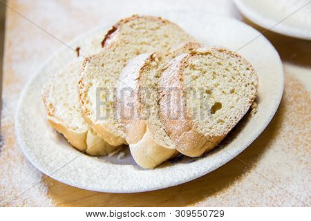 Poudered Slices Of Bread In A White Plate On The Wooden Table