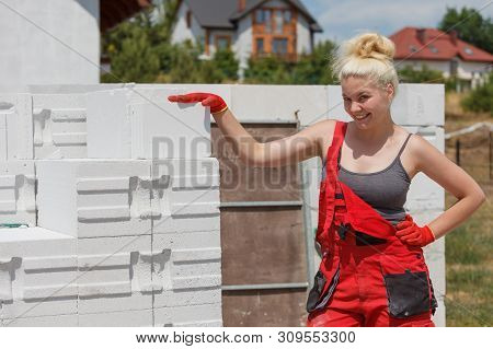 Strong Pretty Woman Working On Construction Site, Building House, Installing Gray Airbricks. Industr