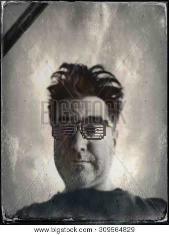 Tintype image of a man with crazy hair and 1980s style 8 bit glasses
