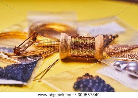 Embroidery Products And Tools. Coil Of Metal Thread, Japanese Beads And Sequins With Pin And Needles