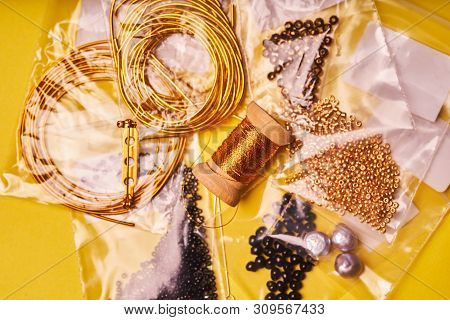 Embroidery Products And Tools. Coil Of Metal Thread, Japanese Beads And Sequins With Pin And Needles
