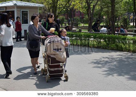 Pyongyang, North Korea - May 1, 2019: Family With Children And A Stroller For A Baby Walks In A City