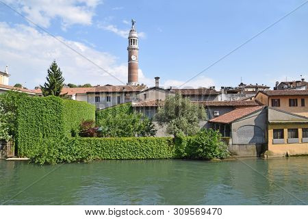 Houses And Buildings On The Bank Of The Oglio River In Palazzolo And In The Background The Torre Del