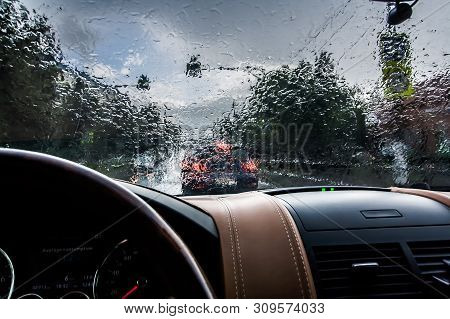 The Car Goes In The Rain. View From The Inside. Raindrops On The Windshield. Poor Visibility And Dan