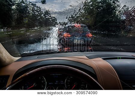 The Car Goes In The Rain. View From The Inside. Raindrops On The Windshield. Poor Visibility And Dan