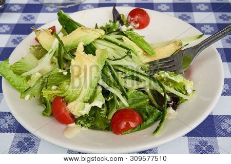 Delicious And Healthy Fresh Avocado And Cucumber Salad With Cherry Tomatoes In A White Plate With Fo