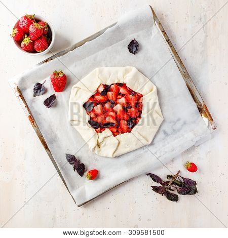Homemade Strawberry Open Cake Of Gallet With Purple Basil And Balsamic Sauce Before Baking On A Ligh