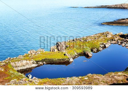 Rocky Seashore. In The Rock Is A Heart-shaped Lake. Clear Clear Water. Sunny Day. Beautiful View.