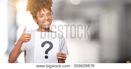Young african american woman holding paper with question mark over isolated background happy with big smile doing ok sign, thumb up with fingers, excellent sign