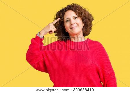 Beautiful middle ager senior woman red winter sweater over isolated background Smiling pointing to head with one finger, great idea or thought, good memory