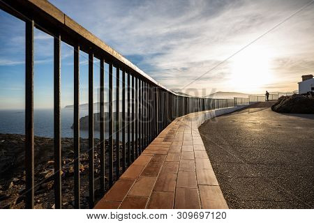 Metallic And Wooden Railing On A Coast Cliff Illuminated By The Sunset Light At Costa Brava (spain)