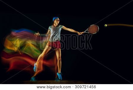 One Caucasian Woman Playing Tennis Isolated On Black Background In Mixed And Stobe Light. Fit Young 