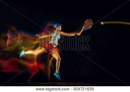 One Caucasian Woman Playing Tennis Isolated On Black Background In Mixed And Stobe Light. Fit Young 