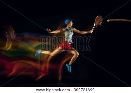 One Caucasian Woman Playing Tennis Isolated On Black Background In Mixed And Stobe Light. Fit Young 